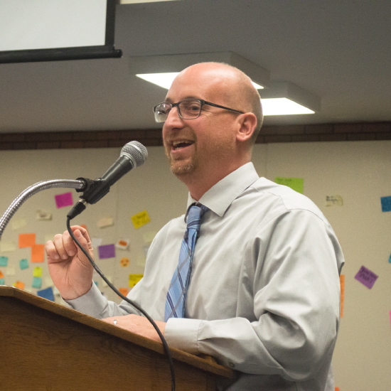  An image of Dr. Croley, principal at McCluer North High School, speaking at a podium. 