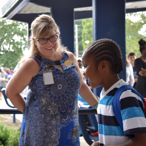 An image of Parker Road's principal, Jane Crawford greeting a student. 